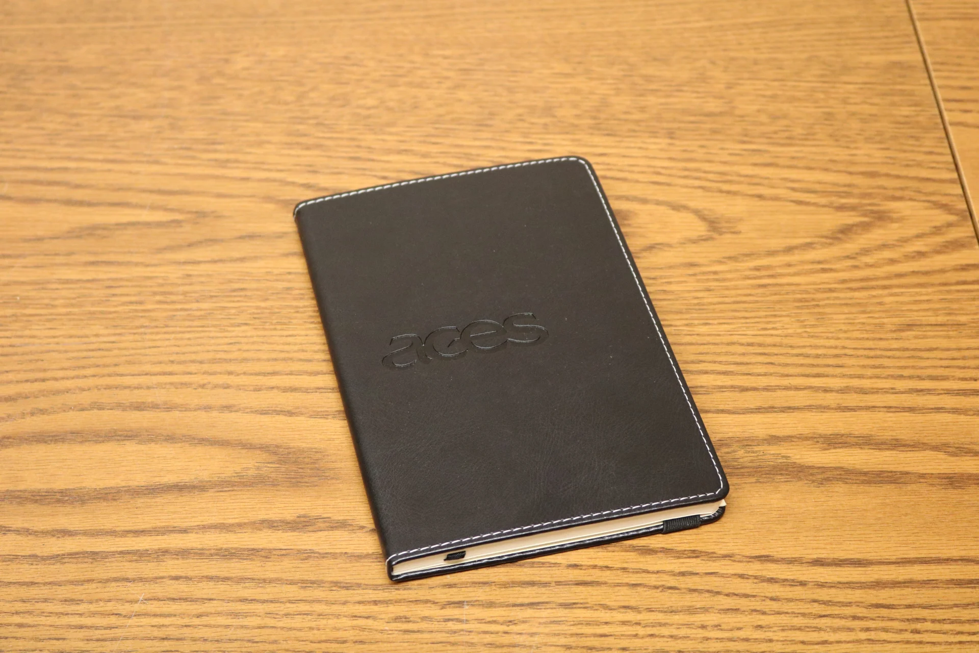 black notebook with embossed ACES logo